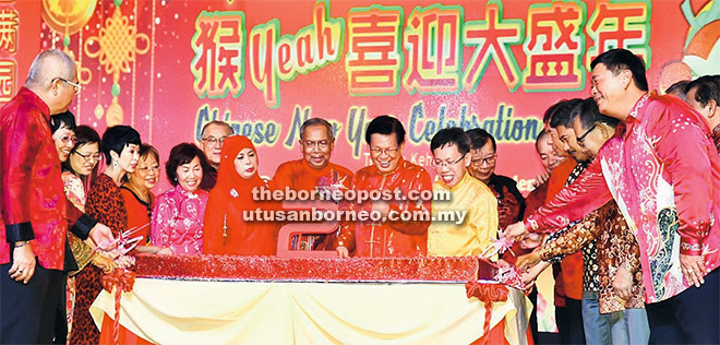 ULANG TAHUN: Adenan (tengah) Lee, Sim memotong kek sempena ulang tahun kali kedua Adenan sebagai Ketua Menteri sambil diperhatikan kenamaan lain.