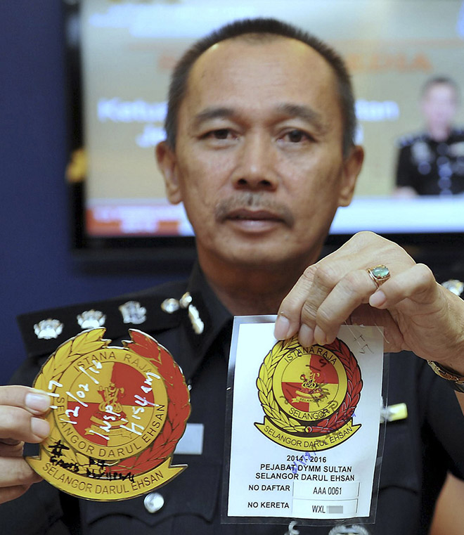 Mohd Sakri shows the car sticker and royalty logo seized from the syndicate. — Bernama photo