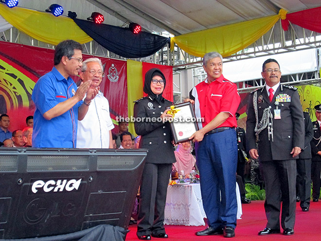 Deputy Prime Minister Datuk Seri Dr Ahmad Zahid Hamidi (second right) presents a certificate to Fatimah to mark the Honorary Rank bestowed on her during the national-level 226th Prisons Day at Padang Merdeka in Kuching. Looking on are (from left) Home Affairs Ministry chief secretary Dato Sri Alwi Ibrahim, Masing and Zulkifli. — Photo by Jeffery Mostapa