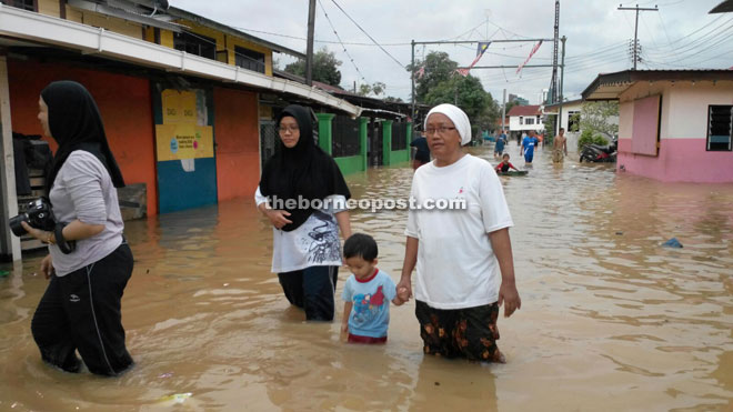 Villagers walking in floodwater  in Kuching.