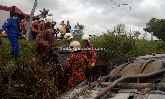 Firemen carry Voon’s charred remains in a stretcher to be taken to Miri Hospital for further investigation.