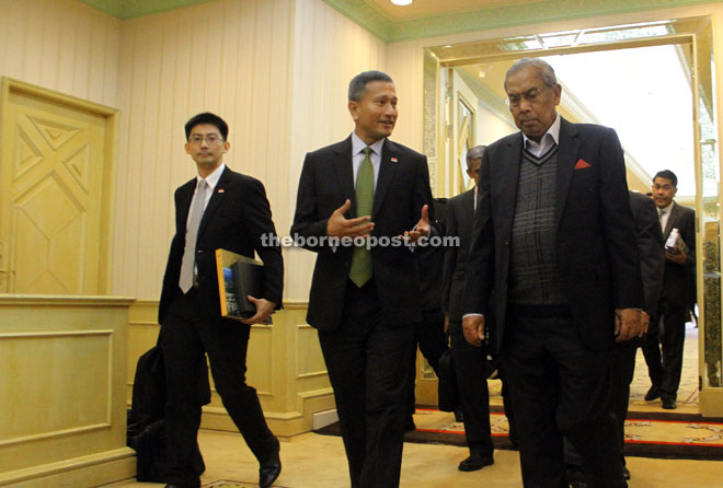 Singapore’s Foreign Affairs Minister Dr Vivian Balakrishnan (centre) discussing a point with Chief Minister Datuk Patinggi Tan Sri Adenan Satem (right) while they were on their way to witness the MoU signing between LCDA and SCE. — Photo by Chimon Upon