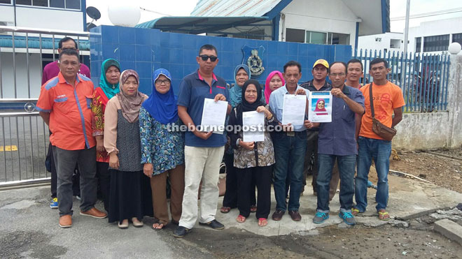 Zuharah (centre) and Roselan (fourth left) and other members of PBB Lingga at Lingga police station. 