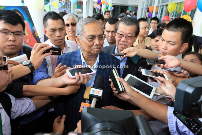 Adenan (centre) smiles when met by the press. — Photo by Kong Jun Liung