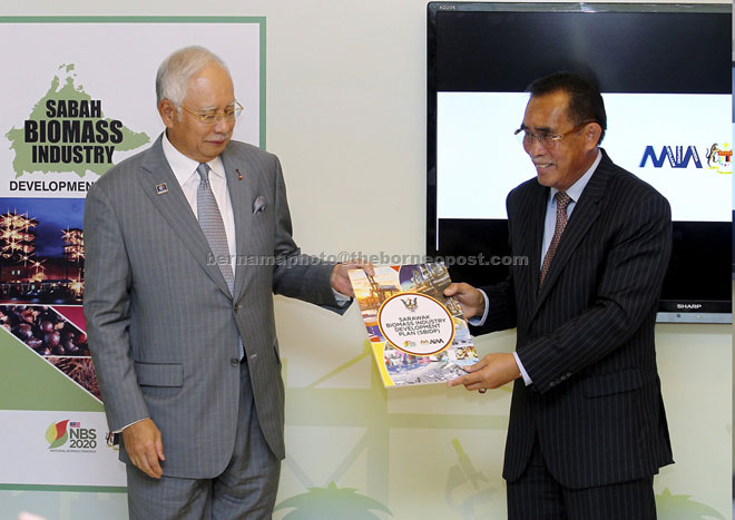 Najib (left) receiving the Sabah and Sarawak Biomass Industry Development Plan from Len Talif in Putrajaya yesterday. — Bernama photo