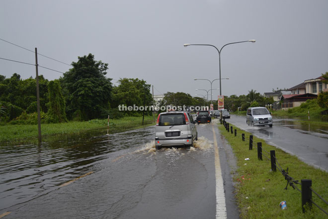 A lower-lying stretch of Ling Kai Cheng Road is washed over by flash flood.