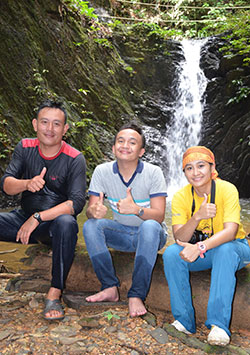 The writer takes a break with Mona (right) and boat driver Norris at the waterfall.