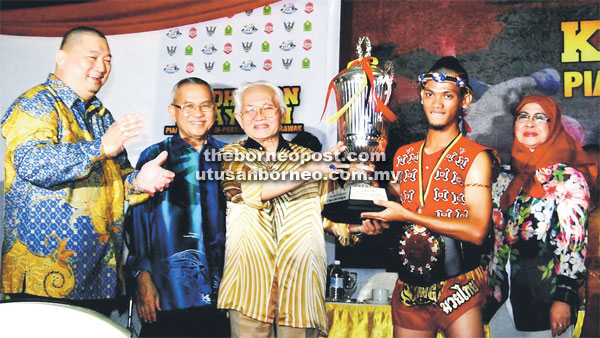 JUARA: Hudson muncul juara Kejohanan Muaythai Piala TYT 2016 menerima Piala Pusingan termasuk tali pinggang daripada Tun Abdul Taib (tiga kiri) sambil disaksikan (dari kiri) Jumaat, Talib dan Rodziah.