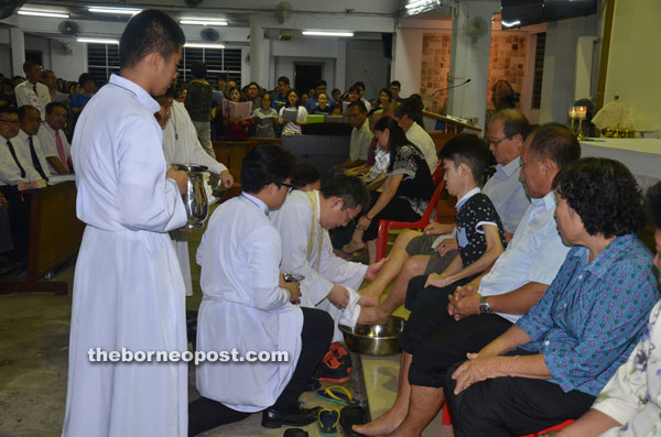 Bishop Ng washes the feet of the  12 parishioners, symbolising what Jesus did for the 12 Disciples.