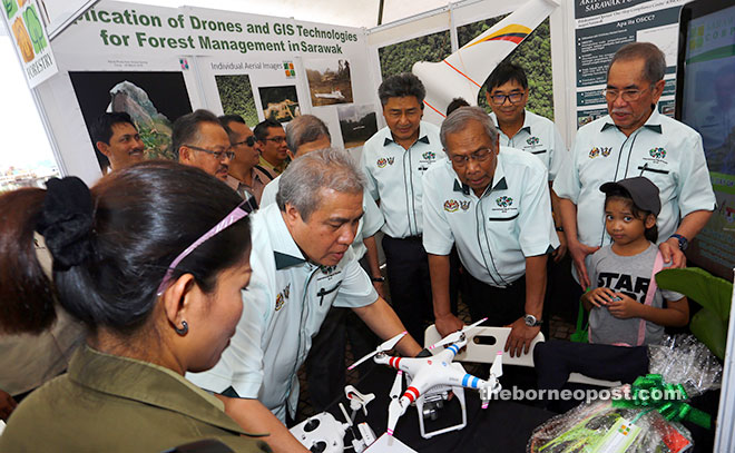 Adenan (second right) and Awang Tengah (second left) take a closer look at a drone technology. Wan Junaidi is at right. —Photo by Muhammad Rais Sanusi