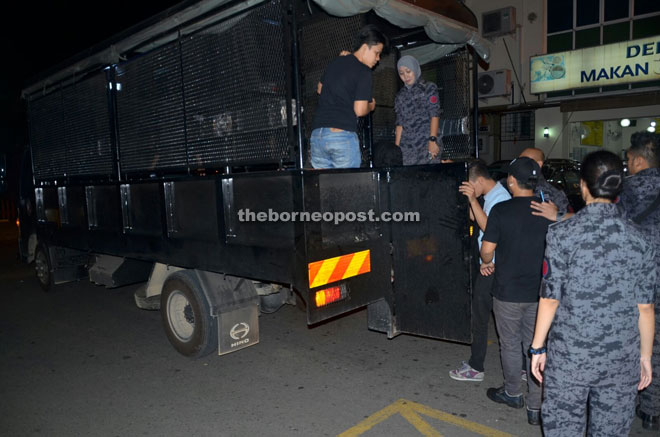 The suspects boarding a police truck. 