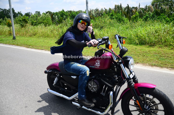 A female big biker enjoys the ride and gives the thumbs-up. 