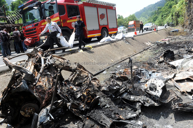 Police personnel carrying one of the bodies to be sent to Raja Permaisuri Bainun Hospital for post-mortem. — Bernama photo