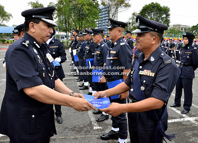 TAHNIAH: Sabtu menyampaikan sijil penghargaan kepada anggota polis sempena sambutan Peringatan Hari Polis Ke-209 di Kuching, semalam.
