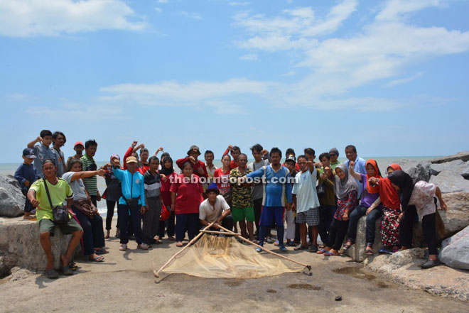 Abdul Mutalib (seventh right) poses for a group photo with several fishermen in Batu Satu.