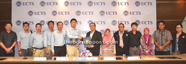 Professor Datuk Dr Abdul Hakim (seventh right) and Chen (sixth left) exchanging MoU documents, witnessed by representatives from UCTS and OM Materials Sarawak Sdn Bhd.