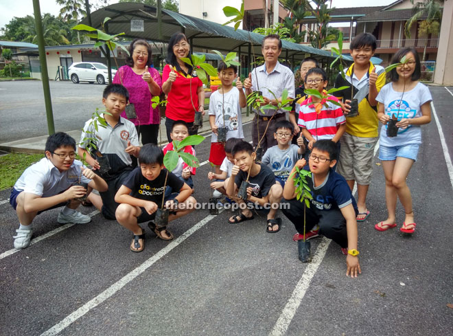 SJK Chung Hua No. 5 headmistress Ho It Chin (standing second left), Penghulu Tan Heng Kee (fourth left) and students welcome the public to adopt a tree to save and green our environment.