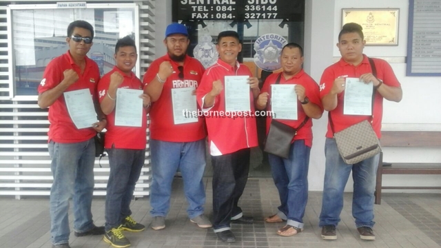 Mohamad Junaidi Sambang (fourth left) and other PBB Bandong Youth members pose with their police reports.