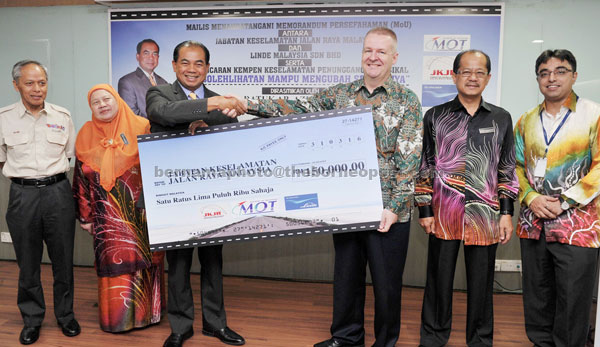 Ab Aziz (third left) receives a mock cheque for RM150,000 from representative of Linde Malaysia, Andy Cook (third right) after launching the safety campaign. — Bernama photo