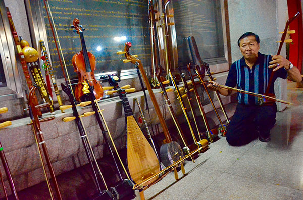 Wong tries out an erhu he made with belian wood. — Photos by Othman Ishak