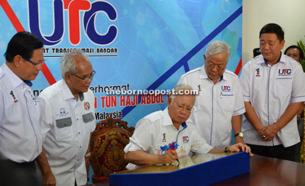 Najib signing the plaque to symbolically mark the opening of the UTC Miri while looking on are (from left) Lee, Jabu, Manyin and mayor Lai.