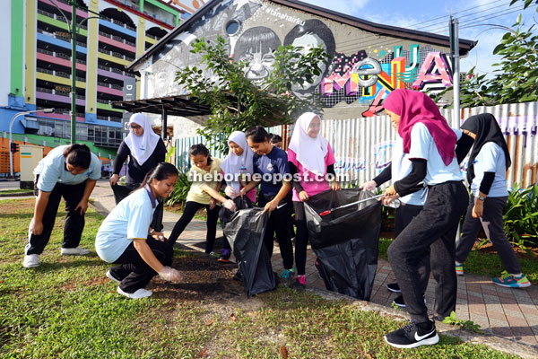 St Mary’s Secondary School students cleaning the street compound in the city during the dengue cleaning campaign at Wayang Street. — Photo by Mohd Rais Sanusi.