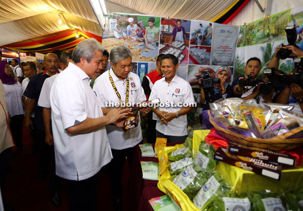 Awang Tengah (left) and Zahid (second left) check out local products as they tour the exhibition area. 