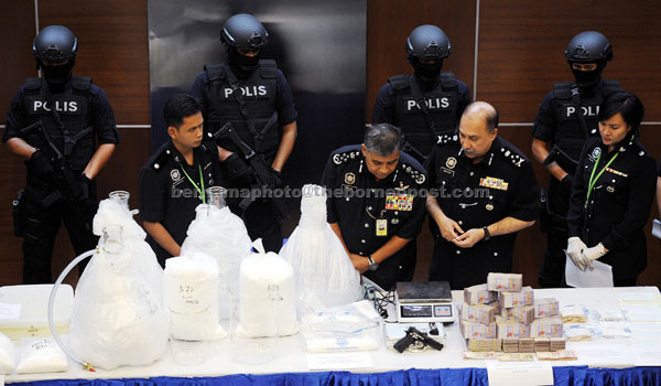 Khalid (second left) taking a closer look at the seized items during the press conference. Accompanying him is Crime Investigation Department (Narcotics) director, Datuk Seri Mohd Mokhtar Mohd Shariff.  (second right). — Bernama photo