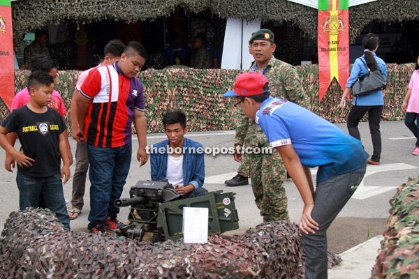 Youngsters check out weapons used by the armed forced at the exhibition area.  