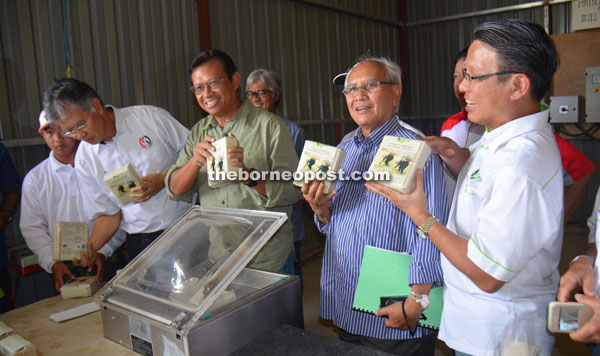 Ahmad Shabery (third right) and Jabu (second right) holding packets of processed Bario rice at Bario Ceria Sdn Bhd. 