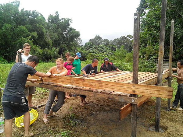 Foreign and local volunteers constructing a house for a disadvantaged family.