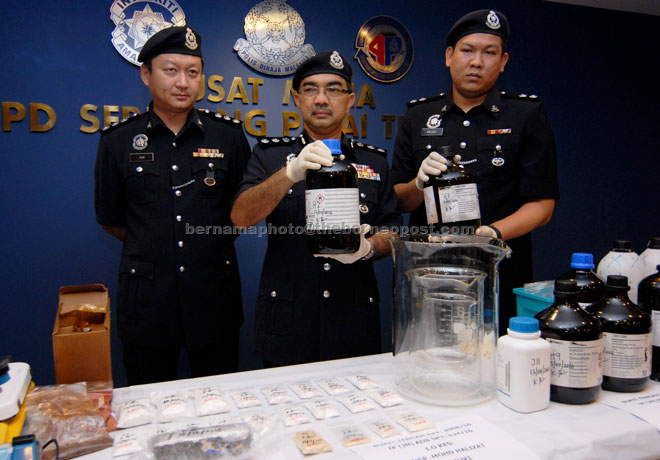 Rusli (centre) and his officers show various types of drugs seized in the raid. — Bernama photo