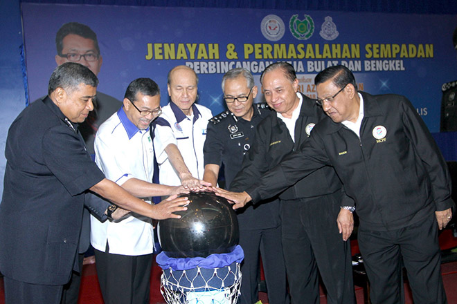 Khalid (left), Azlan Man (second left) and others touching the crystal ball as symbolic launching of the Crime and Border Issues Meeting. — Bernama photo