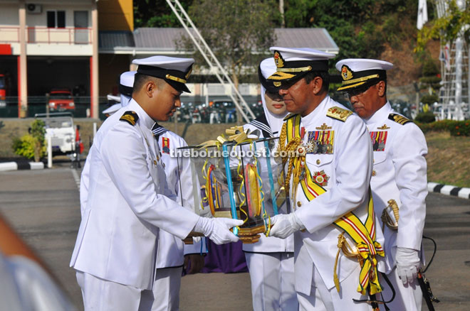 Khairul presenting the best award trophy to a navy officer recipient at the ceremony.
