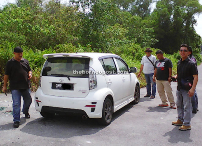 CID personnel seen inspecting the car at the location where a villager spotted the parked vehicle.