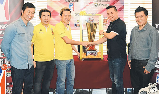 Kuching Lord Tiger representative Chang Lee Kui hands over the championship trophy to Ryco Leong Nyuk On while (from right) Yuwang Group East Malaysia area general manager Chee Chi Vun, Kuching Lord Tiger assistant team manager Bong Boon Ket and organising chairman James Yap Kian Yeung look on at 56 Hotel Kuching last Sunday.