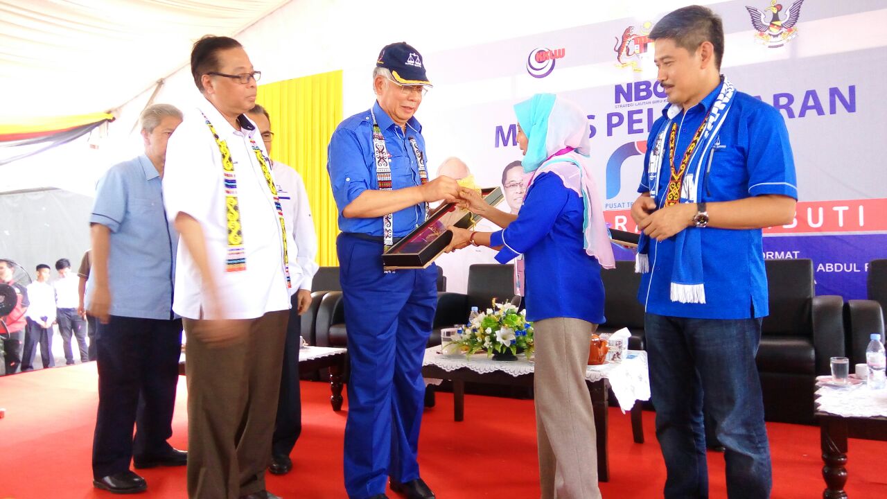 Najib receiving a memento from BN candidate for Bekenu ROsey Yunus, witnessed by Minister of Rural and Regional Development Datuk Seri Ismail Sabri Yaakob (left) and BN candidate for Lambir, Ripin Lamat.