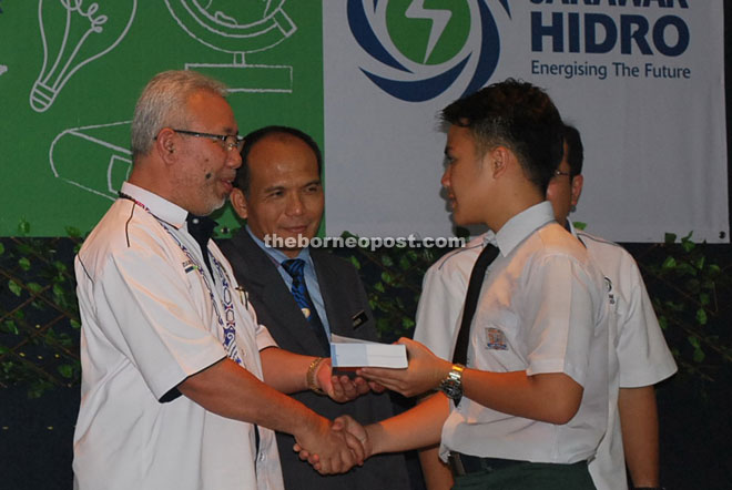 Zulkifle (left) presents the Oxford Fajar English dictionary to a student.