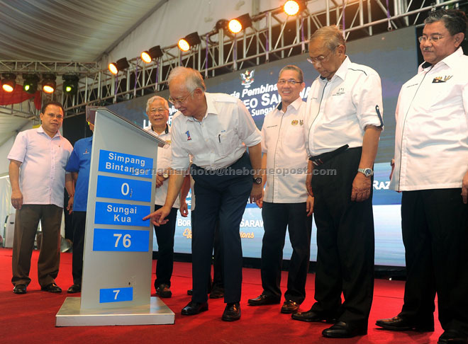 Najib points at a replica milestone at the launching ceremony. From right are Morshidi, Adenan, Fadillah, Manyin and Entulu. — Bernama photo