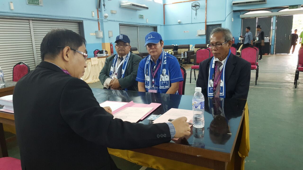 A returning officer processing Dr Johnical Rayong Ngipa's registration at the nomination centre.