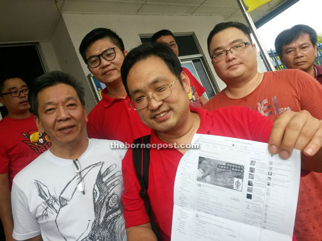 Chong shows a photocopy of the malicious posting on Facebook. David is on Chong’s right while King Wei stands behind them.