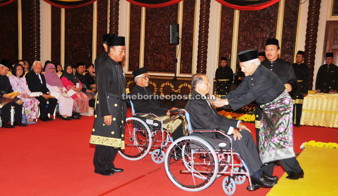 Taib confers Darjah yang Amat Mulia Bintang Sarawak Ahli Bintang Sarawak (ABS) on Midong Gunde. In line to receive the same award is Nawabdeen Saiyd Ahamed.