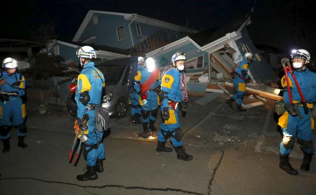 Police officers check a collapsed house after an earthquake in Mashiki town, Kumamoto prefecture, southern Japan, in this photo taken by Kyodo April 16, 2016. Mandatory credit REUTERS/Kyodo