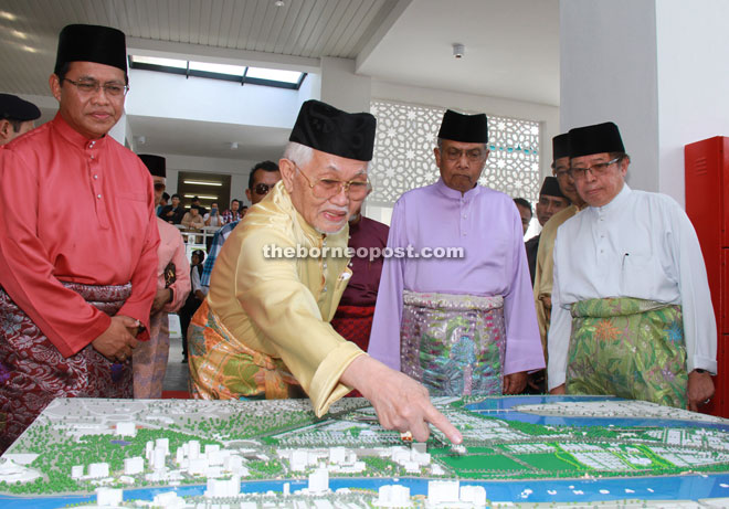 Taib points at the Darul Hana Kuching Master Plan model. From front right are Abang Johari, Adenan and Dr Abdul Rahman.