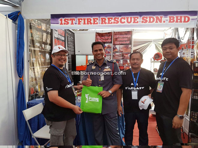 Fire and Rescue Department state director Nor Hisham Muhamaad (second left) is seen with Chai (right) and 1st Fire Rescue team members at Sejiwa Senada Kota Samarahan. 