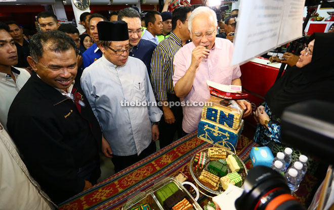 Najib tries a slice of ‘kek lapis’ while Abang Johari (second left), Hishammuddin (behind Abang Johari) and others look on. — Photo by Mohd Rais Sanusi. 