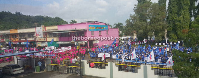 BN supporters (in blue) and Nyomek’s supporters (in pink) gather in front of the nomination centre at Bau District Council.