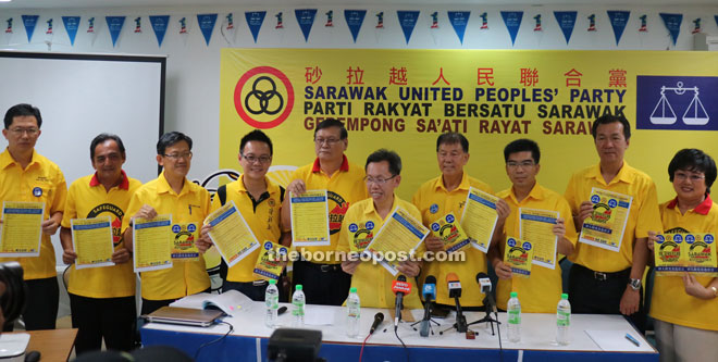 Dr Sim (fifth right) and his party members hold up the SUPP manifesto. 