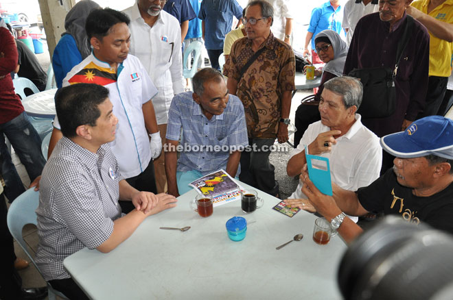 Azmin (left) talking with the people during his walkabout at Satok yesterday. He was accompanied by PKR’s candidate for Satok, Mohd Salleh Shawakatali (second left).