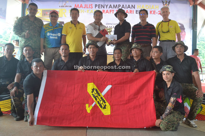 Nyabong (fourth left) presents the champion’s prize for the Best Decorated Raft category to the captain of Briged 9 Infantri Malaysia.